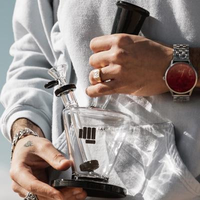 Person holding glass on glass bong