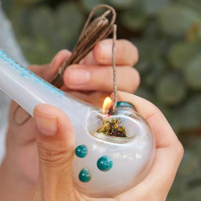 Pipe being lit with a hemp wick